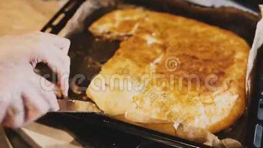 女厨师用手拿着粘粘的自制馅饼从厨房托盘上<strong>拿下</strong>来的特写镜头。
